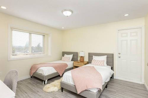 a bedroom with two beds and a window at Home near Downtown Vancouver East@ Joyce Skytrain in Vancouver