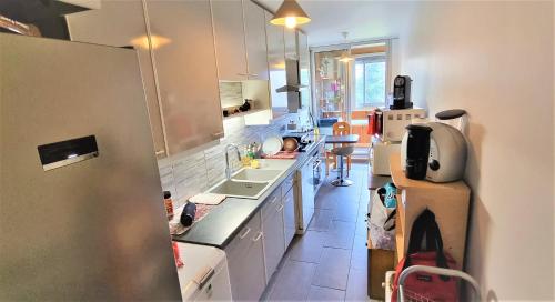 a small kitchen with a sink and a refrigerator at Chambre spacieuse à Sartrouville in Sartrouville