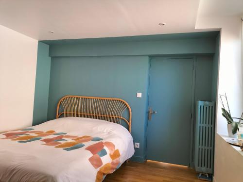 una camera con letto e parete blu di Chambre d hôte a Falaise