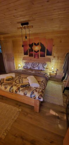 a large bed in a room with wooden walls at Hiska Na Samem v Slovenj Gradcu in Slovenj Gradec