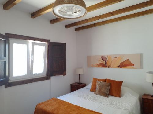 sypialnia z łóżkiem i oknem w obiekcie Casa da Ribeira w mieście Alcanede