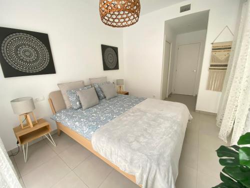 ein Schlafzimmer mit einem Bett und einer Hängeleuchte in der Unterkunft Calpe Beach II - sea & pool view apartment in Calpe