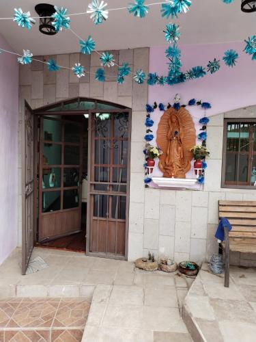 a front door of a building with blue flowers on the wall at Casa Lila in Mineral del Monte