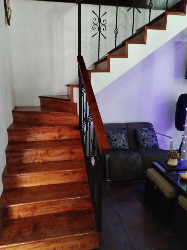 a living room with wooden stairs and a couch at Casa Lila in Mineral del Monte