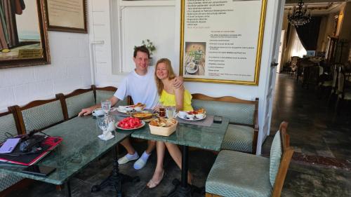 a man and woman sitting at a table with food at Solomon's Mansion Hotel Istanbul in Istanbul