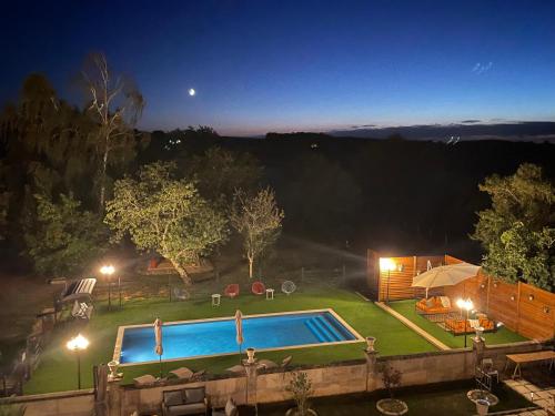 una piscina en un patio por la noche en Le Grand Berger Chambres D'Hotes 
