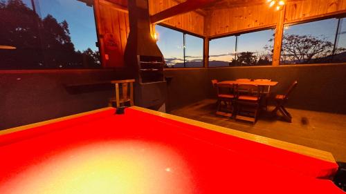 a large red pool in a room with a table at Sheeps Family - Loft, Casa e Apartamento para Temporada - Praia do Rosa in Praia do Rosa