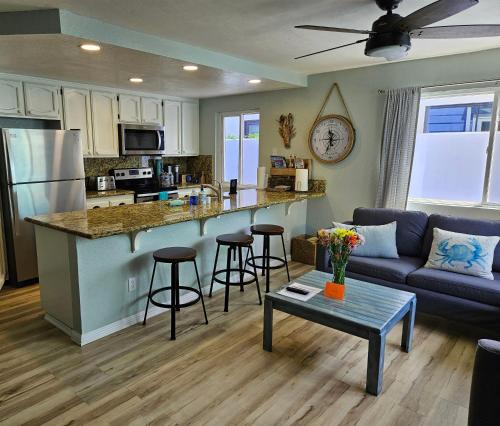 eine Küche und ein Wohnzimmer mit einem Sofa und einem Tisch in der Unterkunft Luna Azul, cozy condo only steps to Mission Beach! Free Internet in San Diego