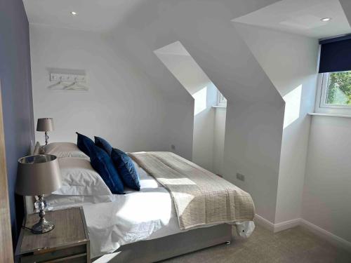 a bedroom with a bed with blue pillows and a window at The Caradoc in Shrewsbury