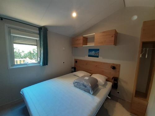 a small bedroom with a bed and a window at Chez Laura et Cyril in Gujan-Mestras