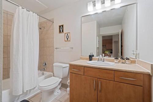 y baño con lavabo, aseo y espejo. en Perfect Location/ Resort Style Pool/Fast Wi-Fi, en Houston