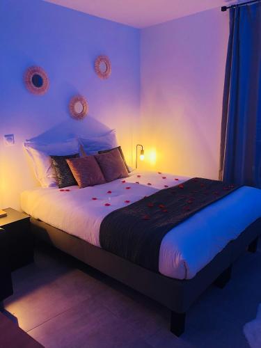 une chambre avec un grand lit avec des lumières violettes dans l'établissement Appart&Spa République, à Dijon