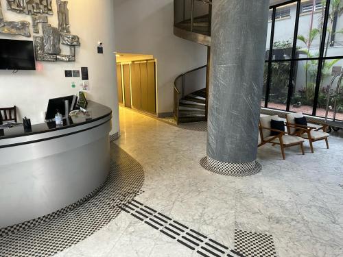 a lobby with a column and chairs in a building at BOOK A FLAT Jardins São Paulo in Sao Paulo