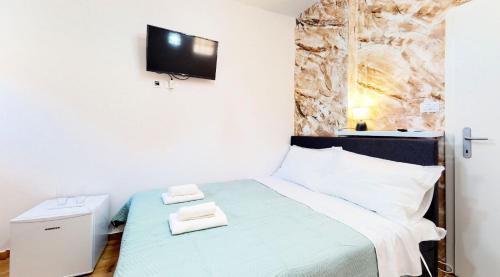 a bedroom with a bed with a tv on the wall at sobe 1-2-3 in Split