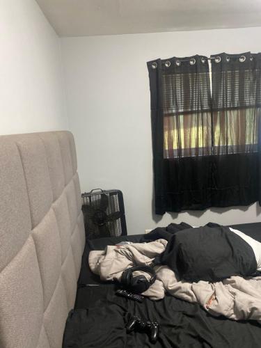 a bed in a room with a window and a couch at Nice stay in Calumet City. in Calumet City
