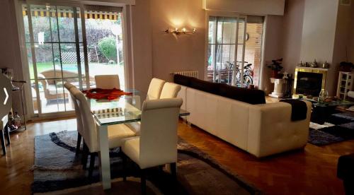 a living room with a white couch and a glass table at Casa de Mirtha in Madrid