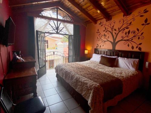 Hotel Real de la Sierra في مازاميتلا: غرفة نوم بسرير ونافذة كبيرة
