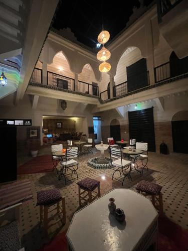 Habitación grande con mesas y sillas en un edificio en Riad Ago, en Marrakech