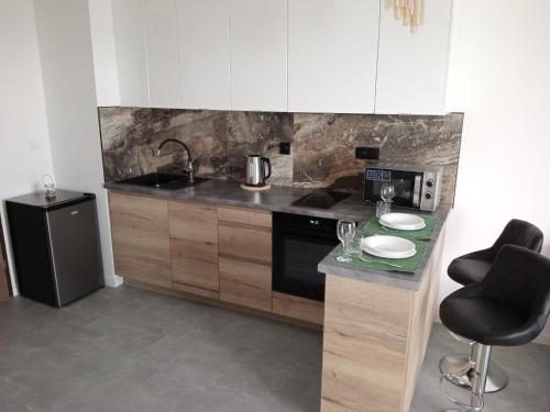 a kitchen with a counter with a sink and a stove at Apartament Apres Ski in Karpacz