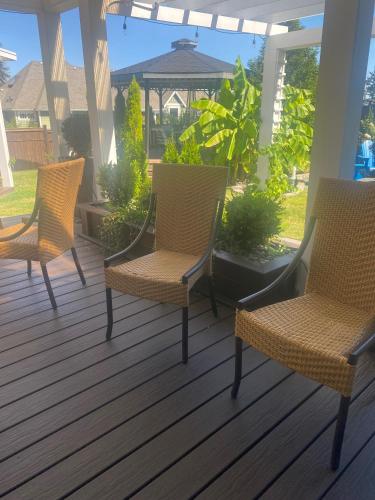 three chairs sitting on a porch with a gazebo at Rockwood House in Nanaimo