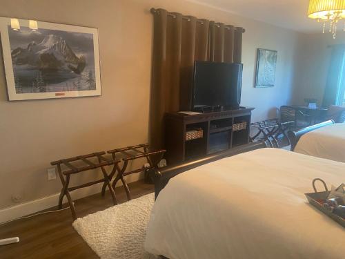 a hotel room with two beds and a flat screen tv at Rockwood House in Nanaimo