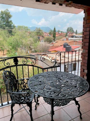 a wrought iron table and chair on a balcony at Hotel Real de la Sierra in Mazamitla