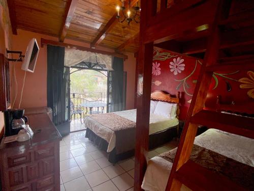 a bedroom with two bunk beds and a balcony at Hotel Real de la Sierra in Mazamitla