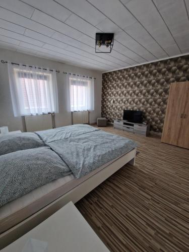um quarto com uma cama e uma televisão em Ferienwohnung/Monteurunterkunft Leopolshall em Staßfurt