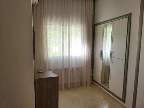 a bathroom with a large mirror and a window at Lido Jinen Hammamet in Hammamet