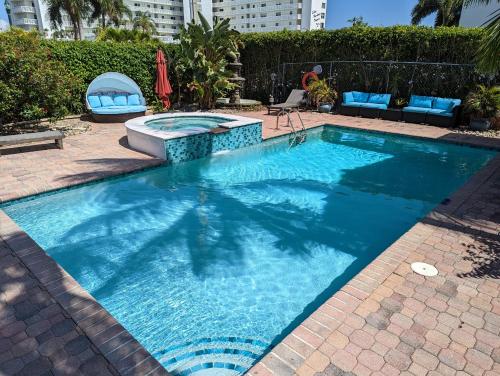 einen Pool mit blauem Wasser im Hof in der Unterkunft 1926 Mediterranean Style Home with Heated Pool Sleeps 12 in West Palm Beach