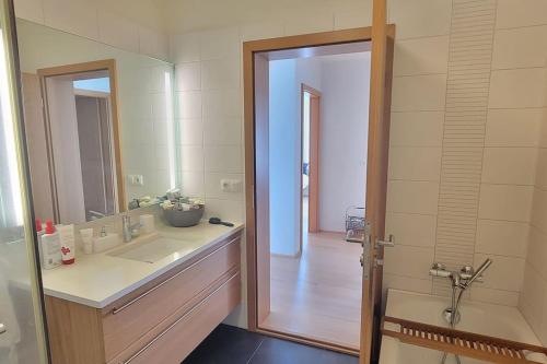 a bathroom with a sink and a mirror and a tub at Pent house dublex with amazing city and Ocean views for 4 rooms 6 people in Reykjavík