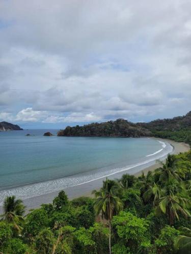 an aerial view of a beach with palm trees and the ocean at Casa en Playa Tambor - A 5 minutos de la playa in Tambor
