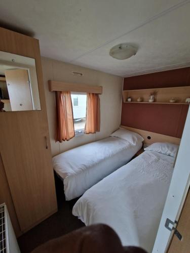 a room with two beds and a window at Three Jays in Saint Osyth