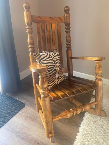 a wooden rocking chair with a pillow on a floor at Rockwood House in Nanaimo