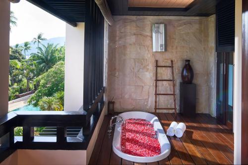 a room with a bath tub on a balcony with a view at Renaissance Koh Samui Resort & Spa in Lamai