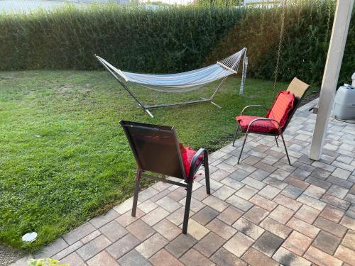 2 Stühle und eine Hängematte im Hof in der Unterkunft Deluxe Family Appartements Haem in Buchheim