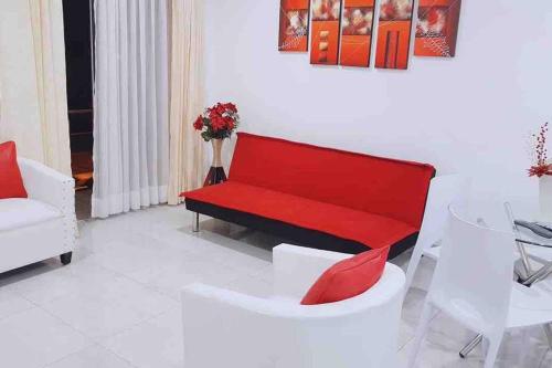 a living room with a red bench and a table at Moderno y nuevo departamento “Casa Blanca” in Trujillo
