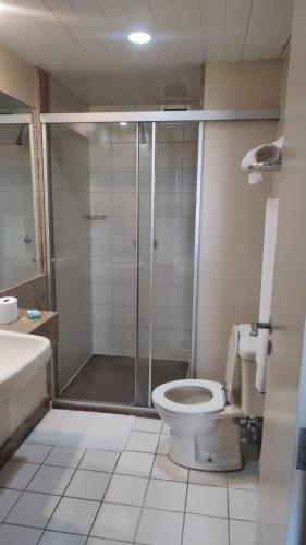 a bathroom with a shower and a toilet and a sink at Studio pé na areia, vista, internet e ar in Macaé