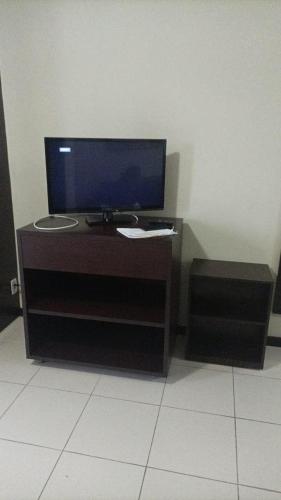 a desk with a monitor and a computer on it at Studio pé na areia, vista, internet e ar in Macaé
