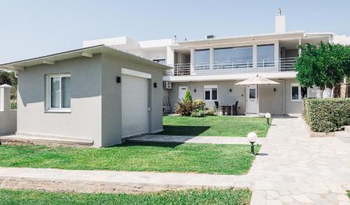 a large white house with a patio and yard at Villa Mare in Mákri