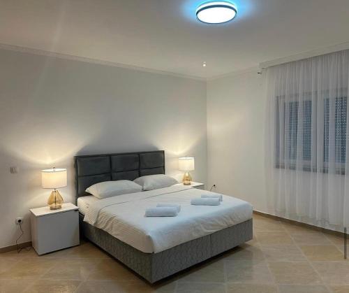 a bedroom with a large bed with two lamps at VILLA ORIJENT HM in Blagaj