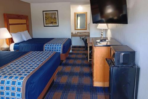 a hotel room with two beds and a tv at Rodeway Inn Lake City I-75 in Lake City