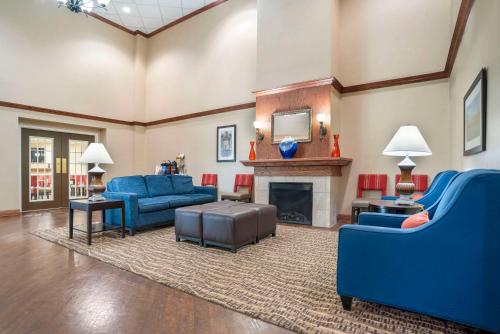 a living room with blue couches and a fireplace at Comfort Inn & Suites Daphne Spanish Fort - Mobile East in Spanish Fort