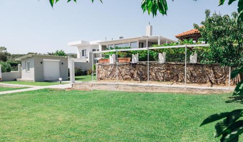 a fence in front of a house with a yard at Villa Mare in Mákri