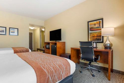 a hotel room with a bed and a desk and a computer at Comfort Inn & Suites Daphne Spanish Fort - Mobile East in Spanish Fort