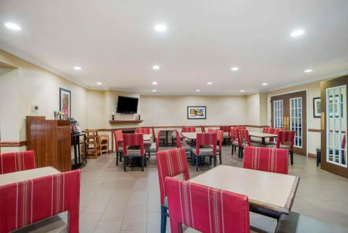 a dining room with tables and red chairs at Comfort Inn & Suites Daphne Spanish Fort - Mobile East in Spanish Fort