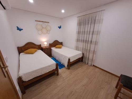 Habitación con 2 camas y ventana en una habitación en Burguesinha AL Entre-os-Rios en Entre -os- Rios