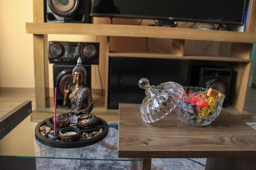 a statue of a buddha and a bowl of fruit on a table at Departamento Chiclayo Perú in Chiclayo