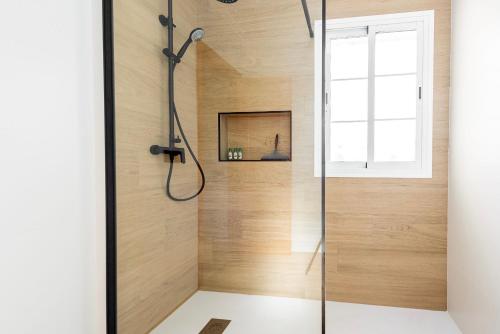 um chuveiro na casa de banho com paredes de madeira e uma janela em Villa Oliva Nerja - Private Pool - heated by Solar Panels em Nerja