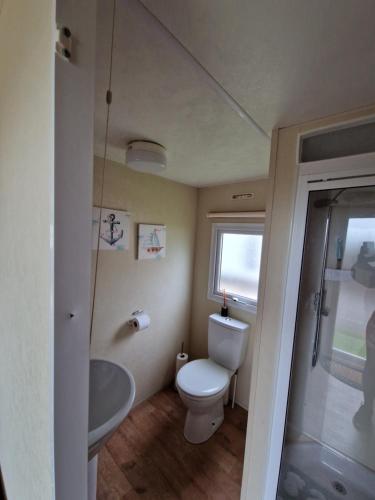 a small bathroom with a toilet and a sink at Three Jays in Saint Osyth